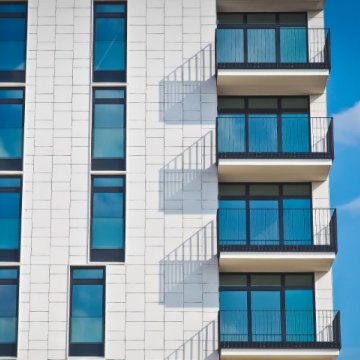light colored apartment with shadows showing off of the balconies 